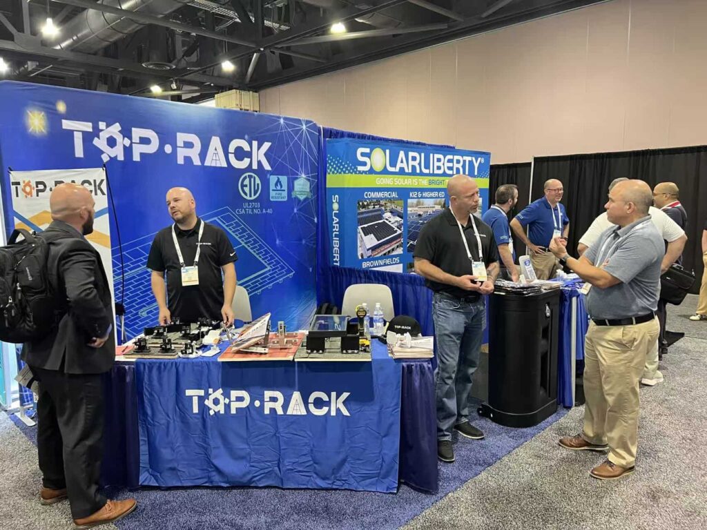 Top Rack Technology booth at RE+ Mid-Atlantic tradeshow in Philadelphia, showcasing solar mounting systems and engaging with industry professionals.
