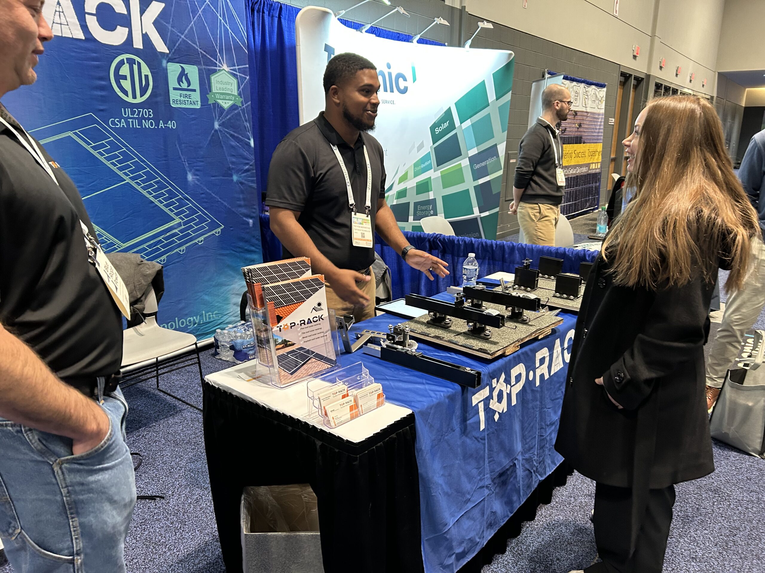 Top Rack Technology at RE+ Midwest 2025 booth demonstrating rooftop mounting systems to attendees